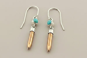 Earrings with silver, copper and turquoise stone design on a gray background
