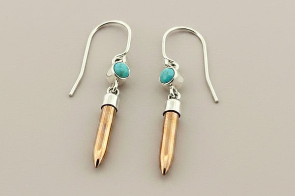 Earrings with silver, copper and turquoise stone design on a gray background