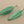 Load image into Gallery viewer, Pair of green leaf-shaped earrings on a gray background
