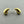 Load image into Gallery viewer, A pair of gold crescent-shaped stud earrings with silver butterfly backings, displayed on a dark gray textured surface.
