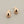 Load image into Gallery viewer, A pair of polished rose gold teardrop-shaped stud earrings with silver posts, displayed on a textured dark gray background.
