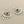 Load image into Gallery viewer, A pair of silver-toned dangle earrings with a fan or sunburst cutout design and a small round red gemstone at the center, shown on a dark gray background.
