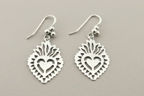 A pair of silver dangle earrings featuring a stylized bird design set against a dark, textured background.