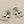 Load image into Gallery viewer, A pair of silver-toned dangle earrings featuring detailed bird motifs with small pearl bead clusters, displayed on a dark gray textured background.

