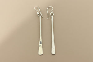 Pair of silver earrings on a gray background