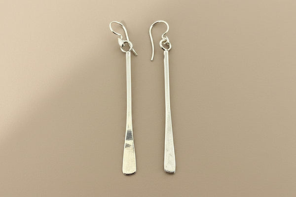 Pair of silver earrings on a gray background