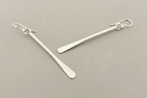 Pair of silver bar earrings on a gray background