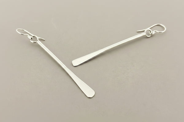 Pair of silver bar earrings on a gray background