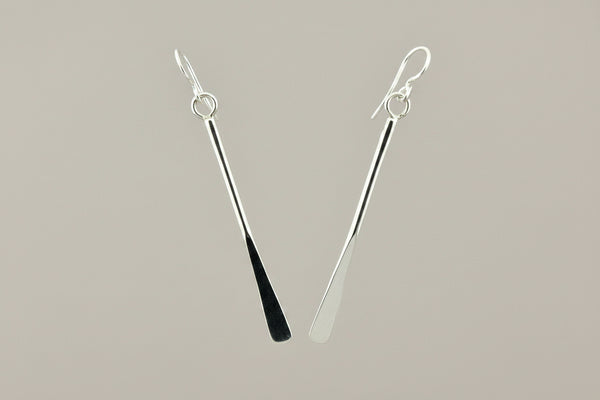 Pair of silver earrings on a gray background