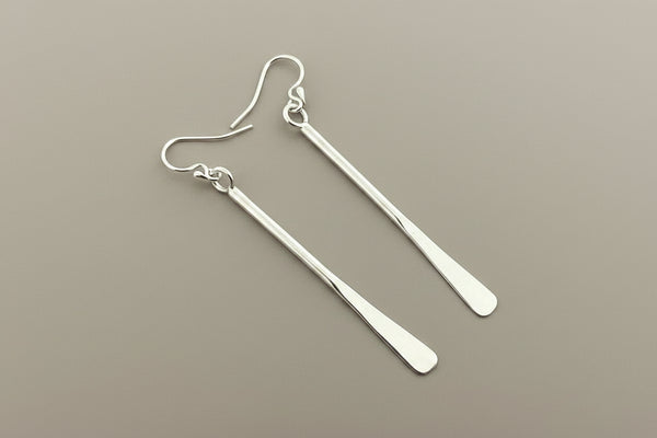 Pair of silver earrings on a gray background