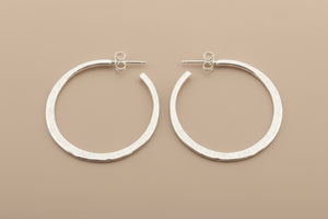 Pair of silver hoop earrings on a gray background