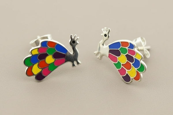 Colorful peacock-shaped earrings on a gray background