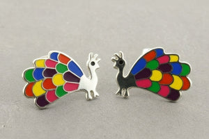 Colorful peacock-shaped earrings on a gray background