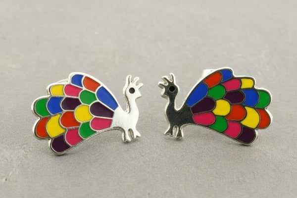Colorful peacock-shaped earrings on a gray background
