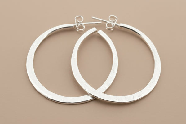 Pair of silver hoop earrings on a gray background
