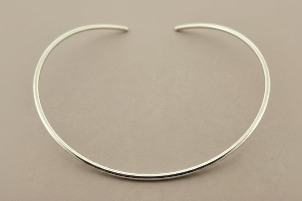 Silver necklace on a gray background