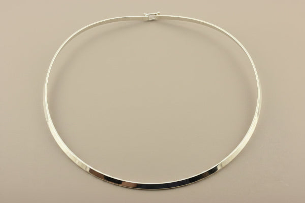 Silver necklace on a gray background