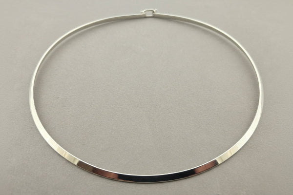 Silver necklace on a gray background