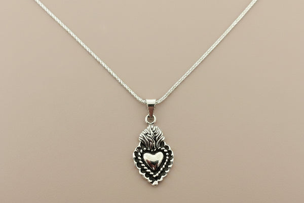 Silver necklace with a heart-shaped pendant on a gray background