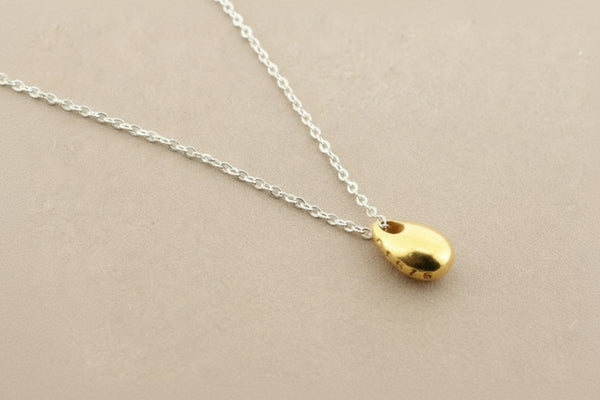 Gold pendant necklace on a gray background