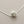 Load image into Gallery viewer, Silver necklace with a textured spherical pendant on a gray background
