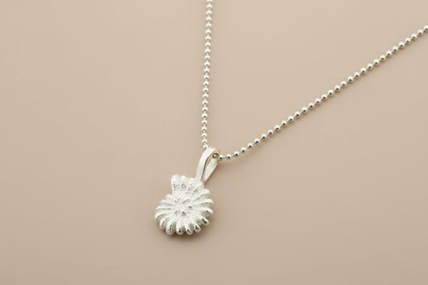 Silver necklace with a detailed pendant on a gray background