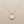 Load image into Gallery viewer, Silver necklace with a round pendant on a gray background
