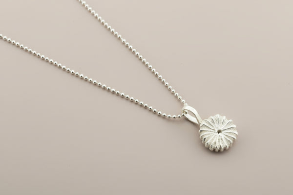 Silver necklace with a small pendant on a gray background