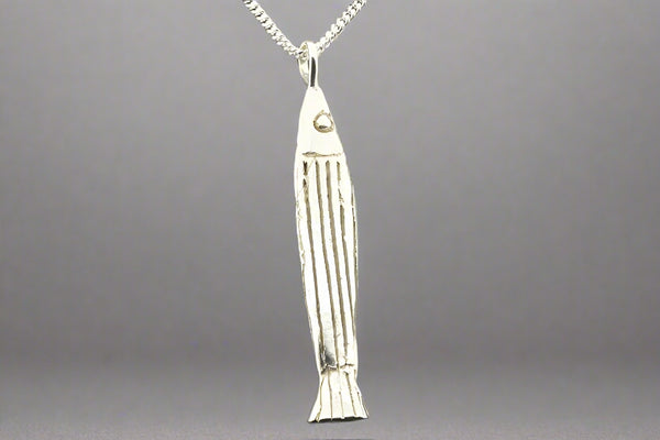 Silver fish-shaped pendant on a chain against a gray background