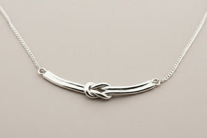 Silver necklace with a unique design on a gray background