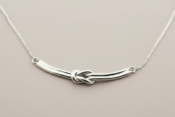 Silver necklace with a unique design on a gray background