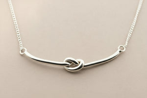 Silver necklace with a unique design on a gray background