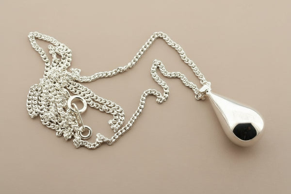 Silver necklace with a teardrop pendant on a gray background