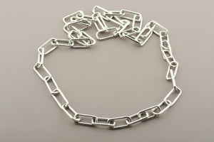 Silver chain necklace on a gray background