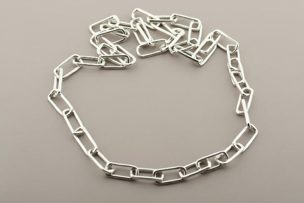 Silver chain necklace on a gray background