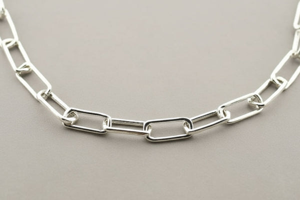 Silver chain necklace on a gray background