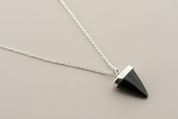 Necklace with a black pyramid-shaped pendant on a gray background