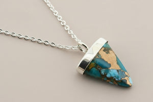 Turquoise pendant necklace on a dark gray background