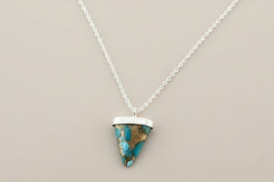 Necklace with a triangular pendant on a gray background