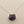 Load image into Gallery viewer, Necklace with a purple faceted pendant on a gray background
