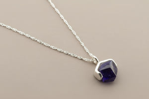 Necklace with a purple gemstone pendant on a gray background