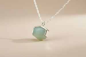 Necklace with a green pendant on a gray background