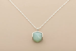 Necklace with a green pendant on a gray background