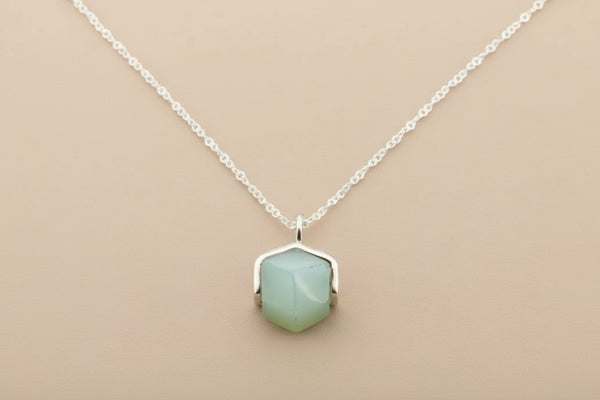 Necklace with a green pendant on a gray background