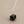 Load image into Gallery viewer, Necklace with a black hexagonal pendant on a gray background
