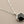 Load image into Gallery viewer, Necklace with a geometric pendant on a gray background
