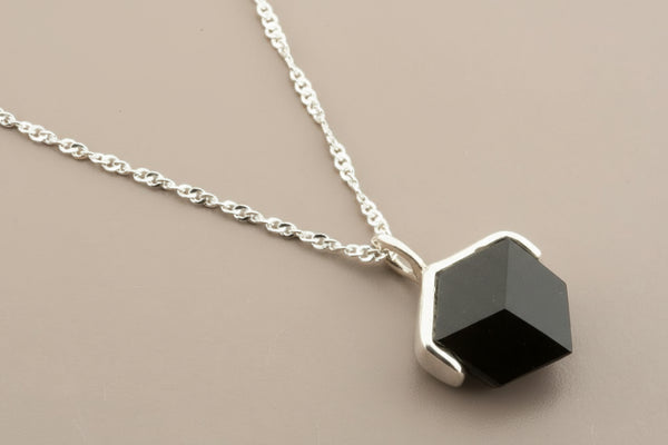 Necklace with a geometric pendant on a gray background