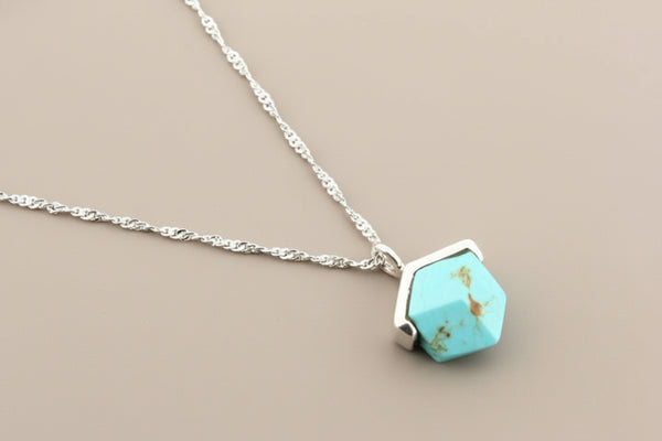 Turquoise pendant necklace on a gray background