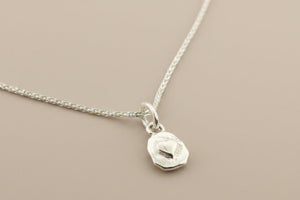 Silver necklace with a pendant on a gray background