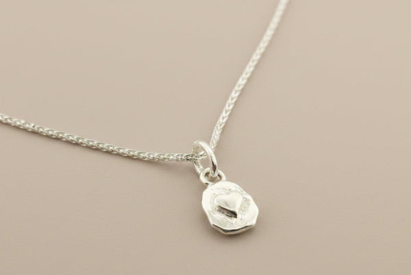 Silver necklace with a pendant on a gray background